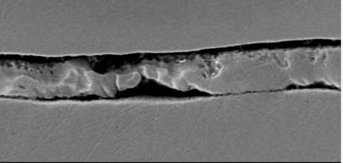 Scanning electron micrograph of a cross-section from a piston housing failure analysis